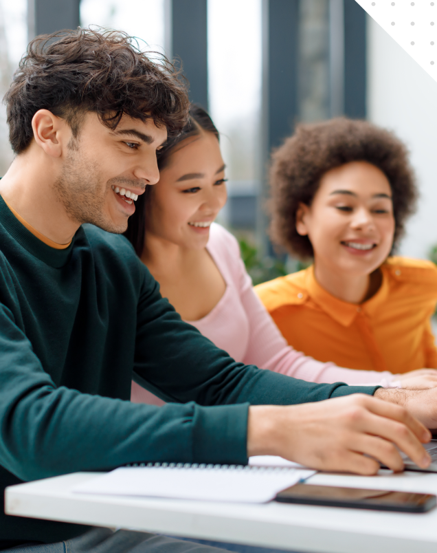 Three students collaborating on a laptop